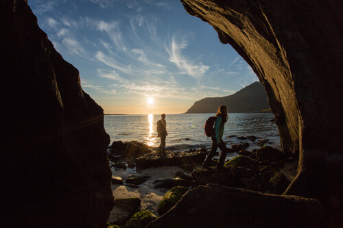 A couple watching the sunset by the water in the Forillon National Park