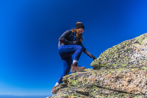 Une fille portant ses bottes LOWA Renegade GTX WS en montant le mont Lafette dans le New Hampshire à l'automne.