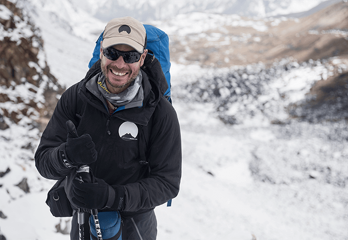 Emmanuel Daigle souriant à la caméra pendant une randonnée dans l'Himalaya.