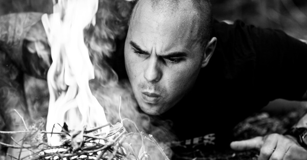 Keven Martel lighting up a fire during his survival training